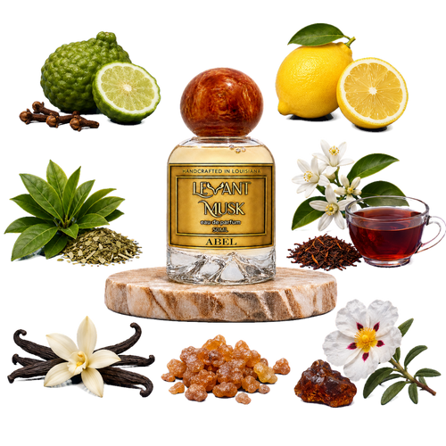 A bottle of Levant Musk eau de parfum labeled Abel centered on a white background, surrounded by its natural ingredients including lemongrass, kumquats, lemons, vanilla flowers, vanilla pods, rooibos tea leaves, and a cup of brewed tea.