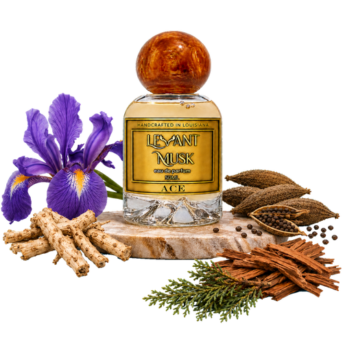 A bottle of ACE by Levant Musk a Eau de Parfum with a amber cap, surrounded by natural ingredients including purple irises, turmeric roots, cinnamon sticks, and green herbs on a white background.
