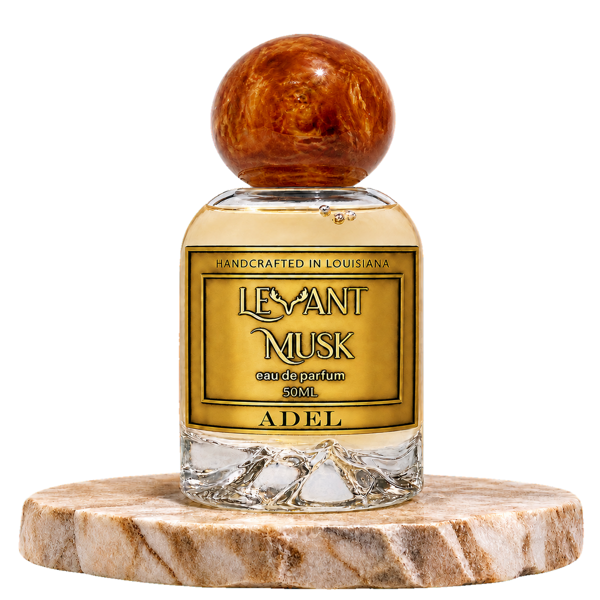 A bottle of Adel eau de parfum by Levant Musk, featuring a round amber cap and a gold label, displayed on a marble slice coaster against a white background.