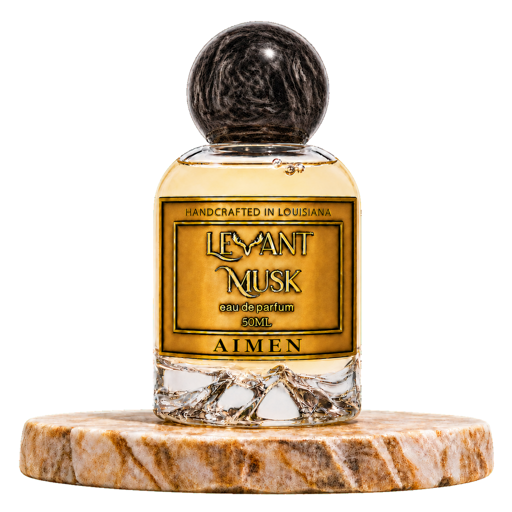 AIMEN by Levant Musk, 50 mL eau de parfum in a round glass bottle with black cap on a marble stand, transparent background