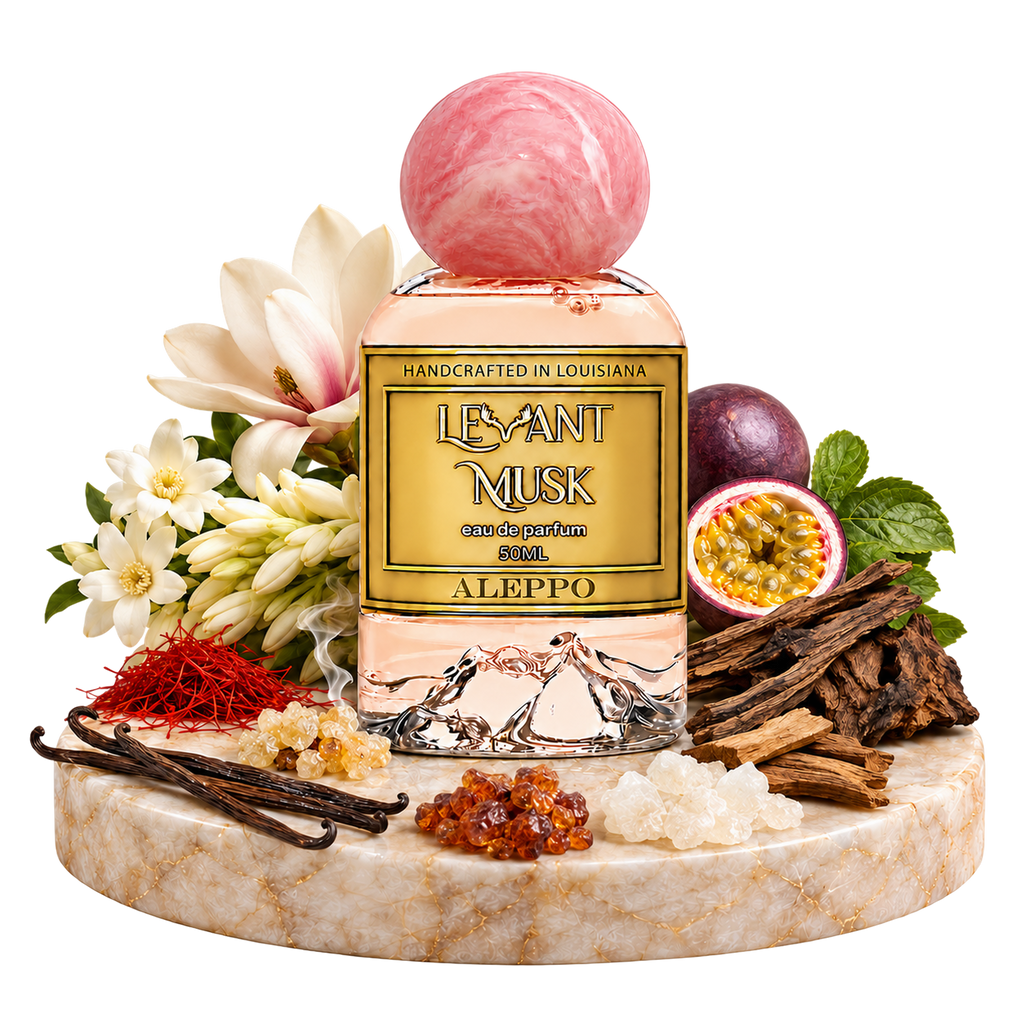 A perfume bottle labeled Allepo, by Levant Musk styled on a marble pedestal with floral and botanical ingredients including white lilies, vanilla pods, saffron, amber resin, cinnamon sticks, and a passion fruit, against a white background.