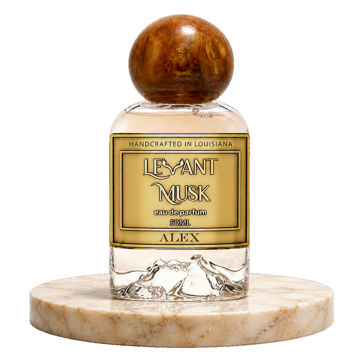 A clear glass perfume bottle with a round polished amber cap and a gold label reading ALEX,  by Levant Musk 50 ml eau de parfum', displayed on a round beige marble base against a white background.