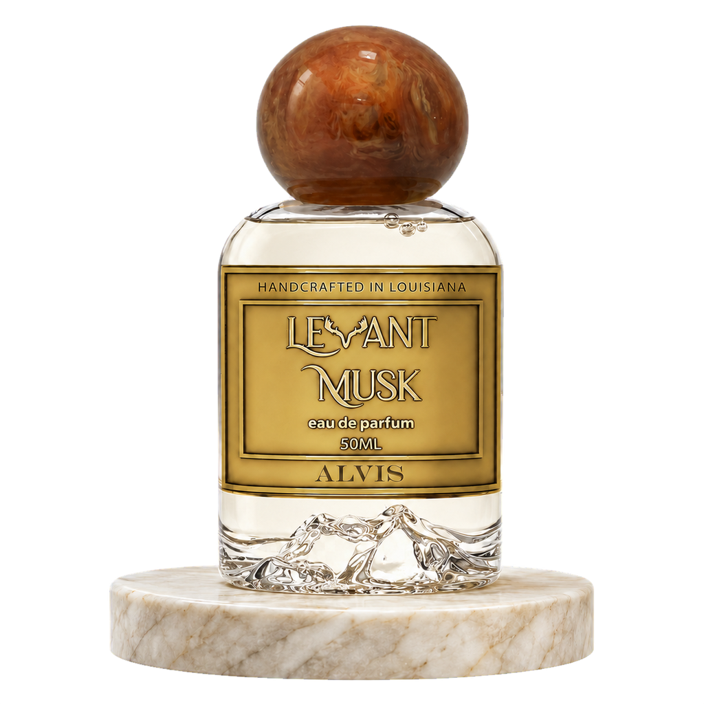 A bottle of ALVIS LeVant Musk Eau de Parfum, 50mL, featuring a round polished brown cap and a clear glass body resting on a white marble base, set against a plain transparent background.