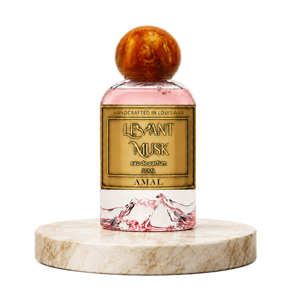 A perfume bottle labeled AMAL, by Levant Musk, featuring a pink liquid, a gold label, and a round amber-brown wooden cap, displayed on a round marble pedestal against a white background.