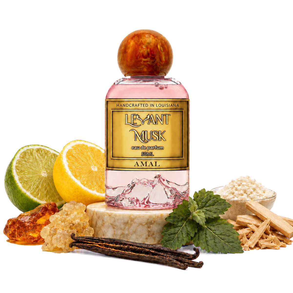 A bottle of Amal eau de parfum, by Levant Musk styled with its scent ingredients including a lime, lemon, vanilla beans, mint leaves, amber resin, and sandalwood pieces on a white background.