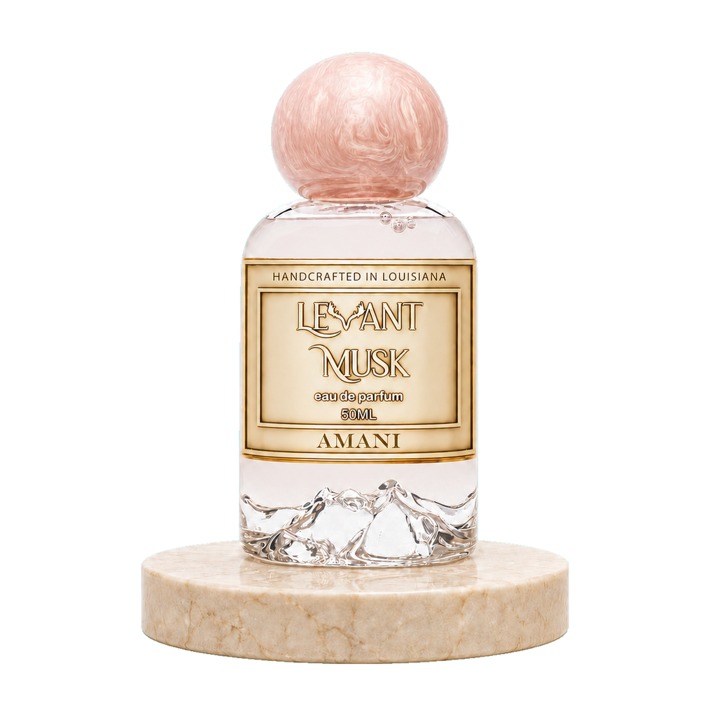 A 50ml perfume bottle of Amani by Levant Musk Eau de Parfum, featuring a clear glass bottle with a textured pink spherical cap and a gold label, resting on a round beige marble base against a white background.