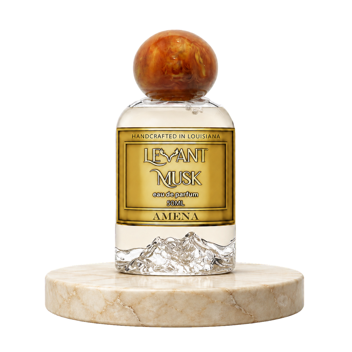 A 50ml bottle of Amena by Levant Musk eau de parfum, featuring a clear glass body with a gold label, a textured mountain design at the base, and a round, marbled amber-brown cap, displayed on a round marble pedestal against a white background.