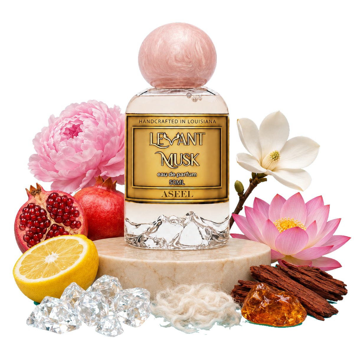 A bottle of Aseel, by Levant Musk, Monroe, LA styled with its scent ingredients including pink flowers, pomegranate, lemon, cinnamon, and crystals on a marble pedestal against a white background.