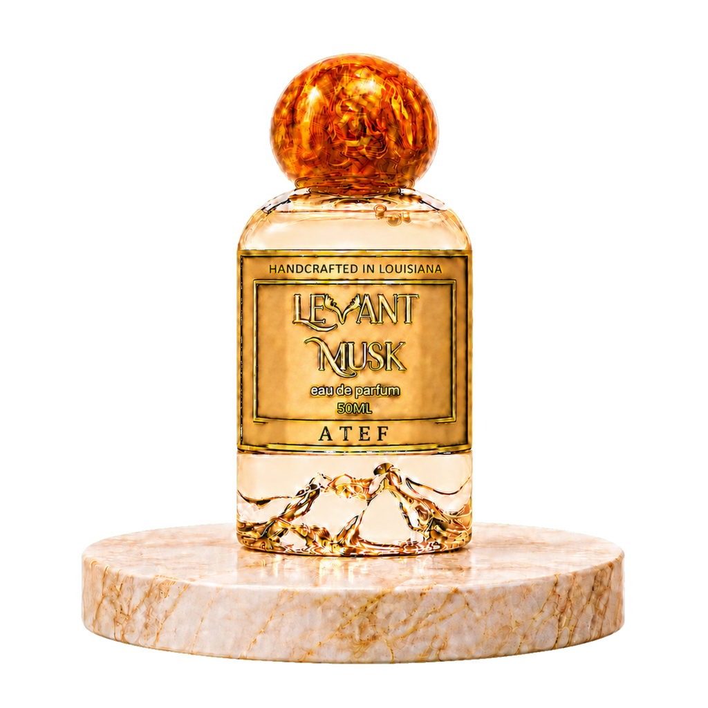 A bottle of ATEF Levant Musk Eau de Parfum with a gold-toned label and a round amber-colored cap, displayed on a round marble pedestal against a white background.