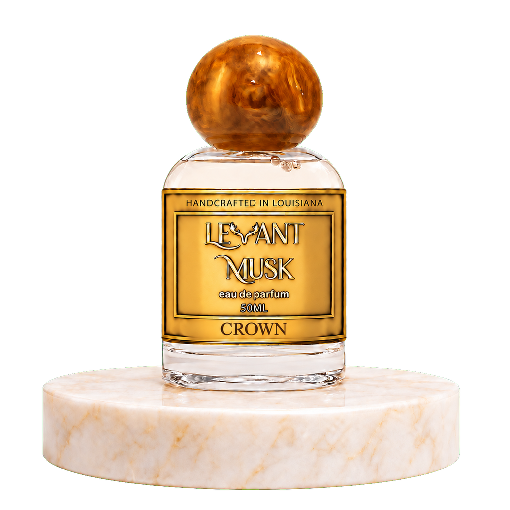 A 50ml bottle of Crown  by Levant Musk Eau de Parfum, featuring a gold label and a round amber cap, displayed on a white marble pedestal against a white background.