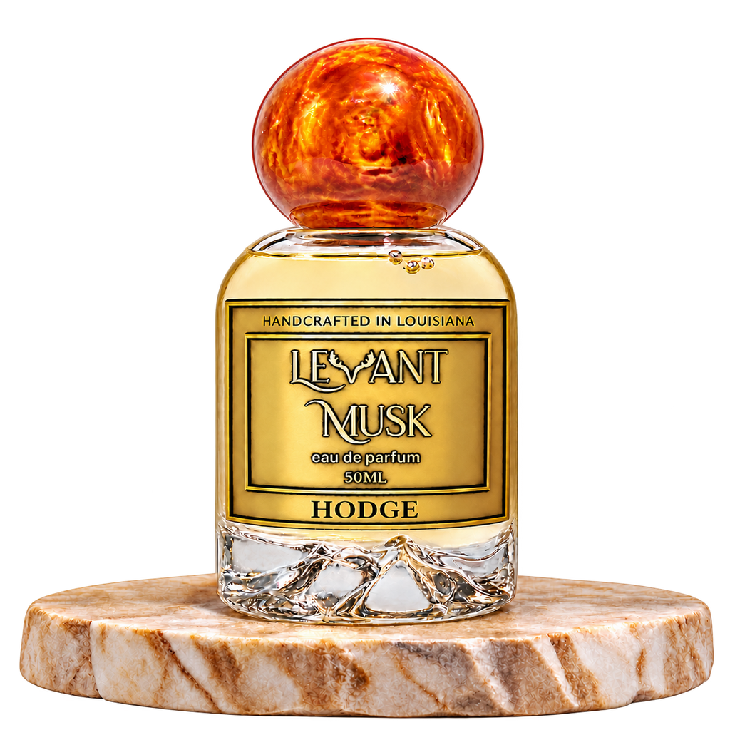 HODGE by Levant Musk, 50 mL eau de parfum in the orange-gold marbled-cap bottle on cream marble, transparent background.