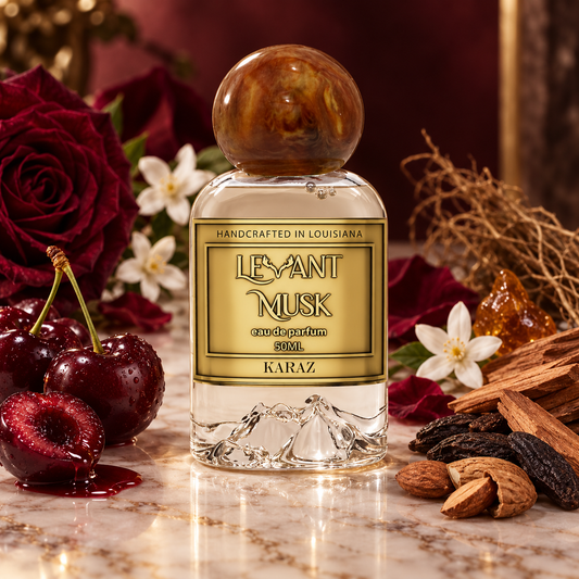 A 50ml glass perfume bottle labeled KARAZ BY 'LEVANT MUSK' styled on a marble surface with red roses, cherries, cinnamon, and almonds in the background.