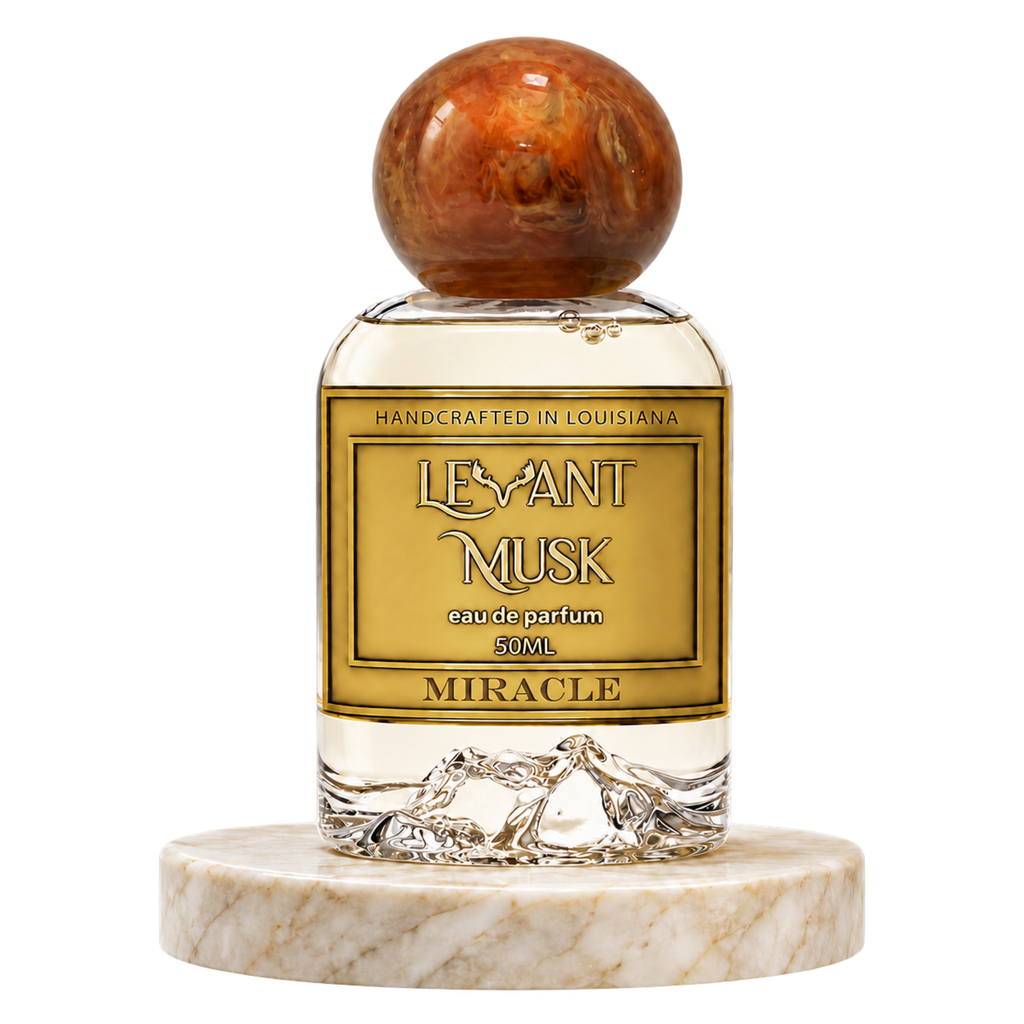 MIRACLE 50 mL Eau de Parfum bottle by Levant Musk with an amber spherical cap on a marble pedestal, on a transparent background.