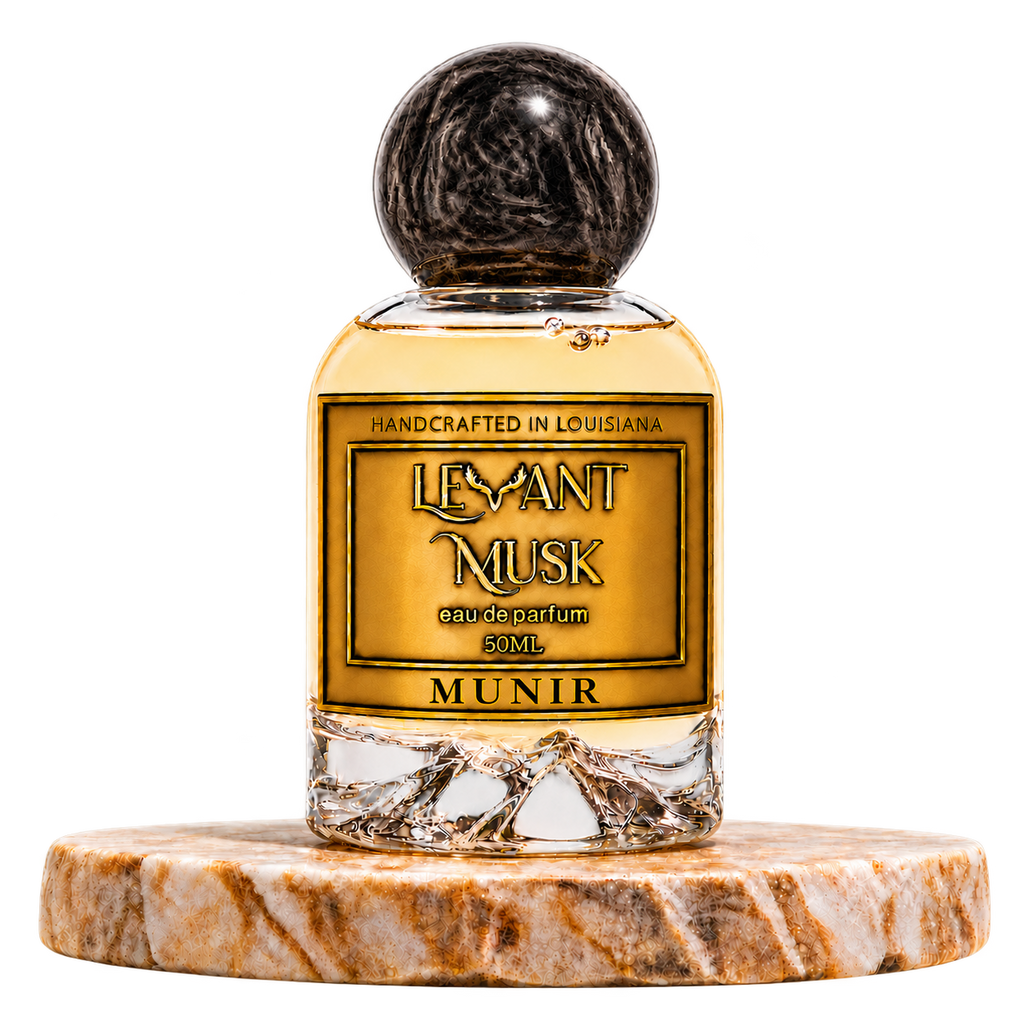 MUNIR by Levant Musk, 50 mL eau de parfum with black marbled cap on a marble pedestal, transparent background