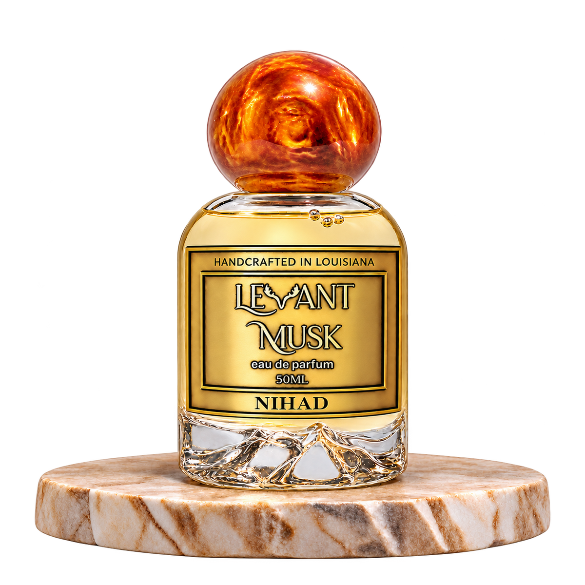 NIHAD by Levant Musk, 50 mL eau de parfum with a orange-gold marble cap on a cream marble plinth, transparent background.