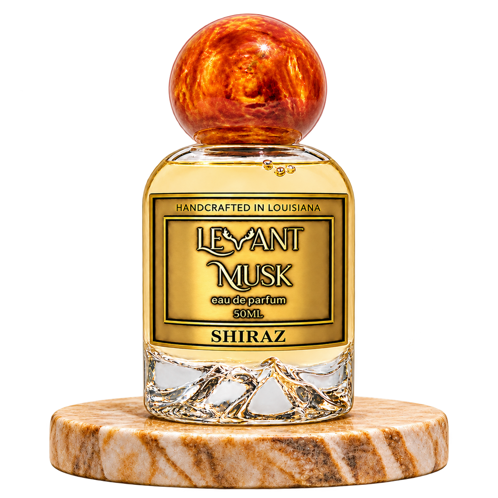 SHIRAZ by Levant Musk, 50 mL eau de parfum with orange-gold marbled spherical cap, standing alone on a marble pedestal with transparent background