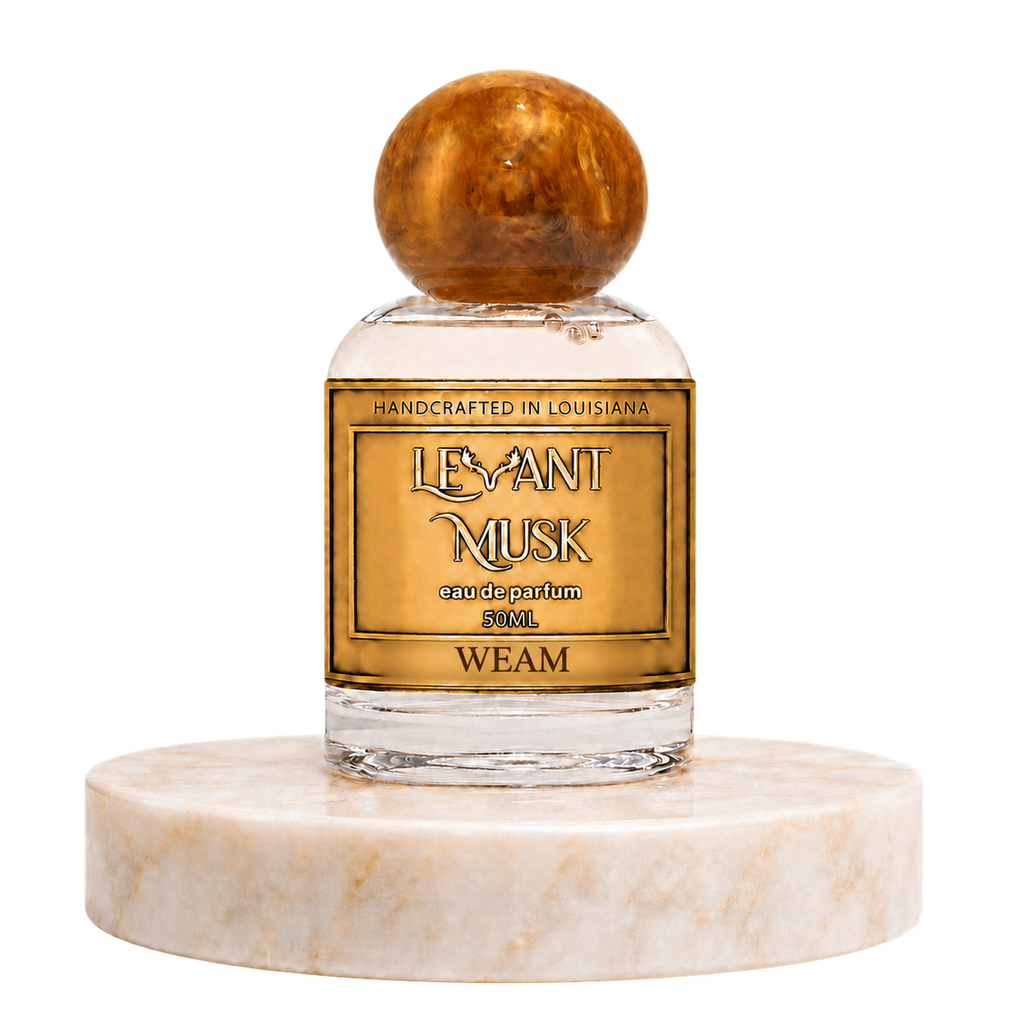 WEAM by Levant Musk, 50 mL eau de parfum with the approved antler label and orange marble cap, on a warm cream marble pedestal.
