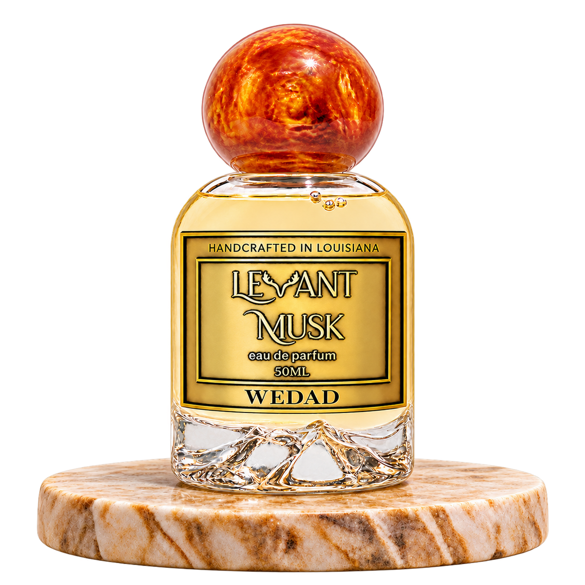 WEDAD by Levant Musk, 50 mL eau de parfum with orange-gold marbled spherical cap, standing alone on a marble pedestal with transparent background