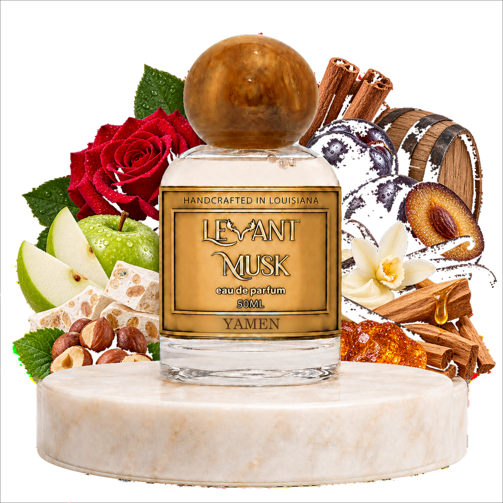 A bottle of Yamen by Levant Musk Eau de Parfum centered on a white marble pedestal, surrounded by fragrance-inspired ingredients including red roses, green apples, cinnamon sticks, vanilla, and amber resin on a white background.